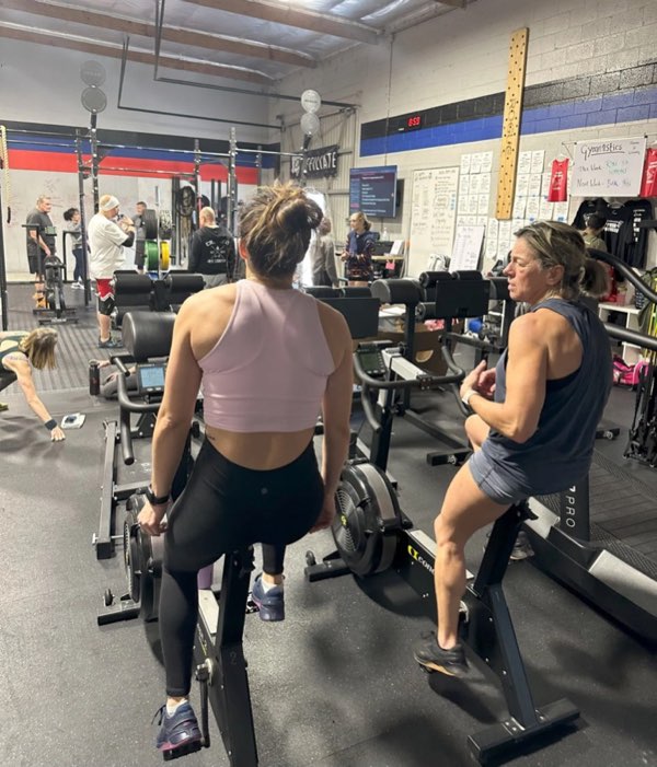 Members on bike ergs during a conditioning class.