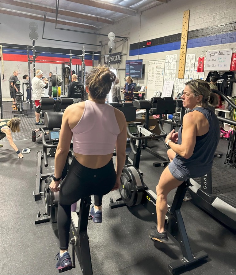 Members on bike ergs during a conditioning class.