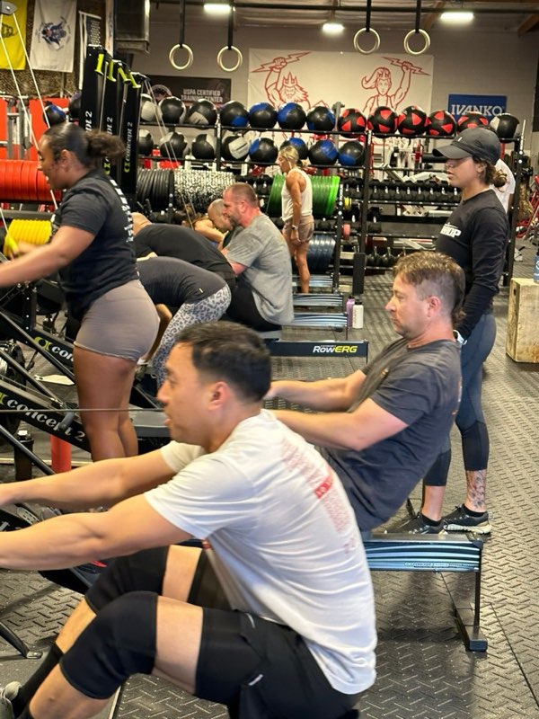 A coach working with members on the rowers.