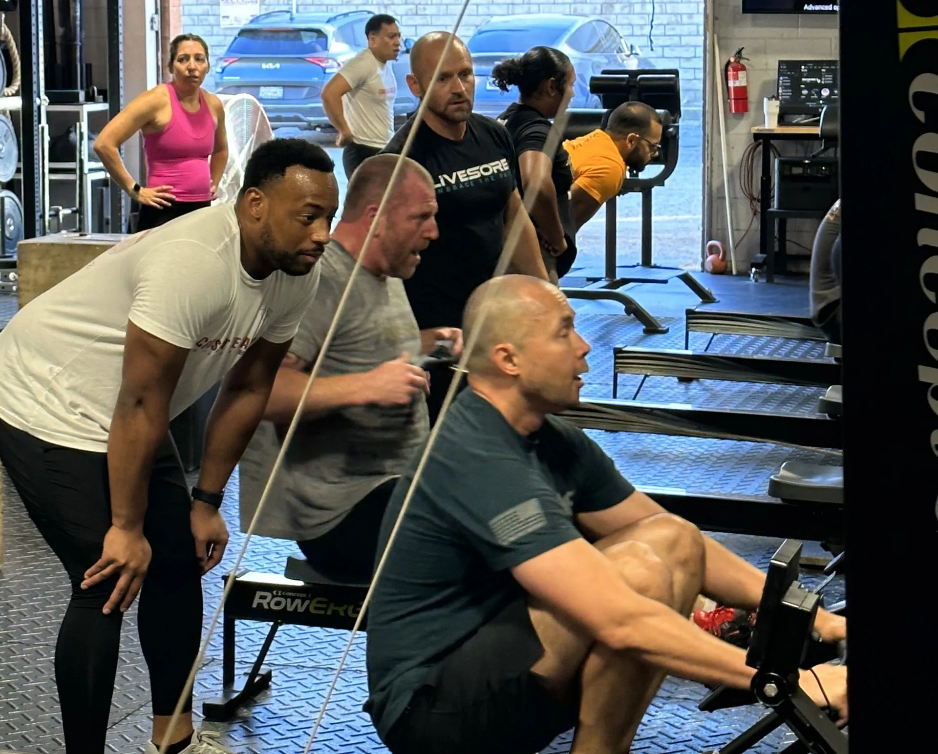 A coach guiding members through a rowing workout.