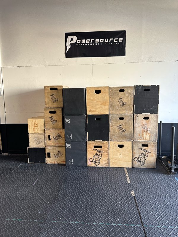 A wall of wooden and foam plyo boxes under the PowerSource logo.