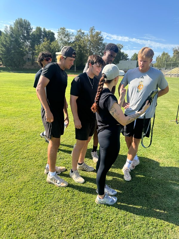 A coach showing a group of athletes their results on a tablet.