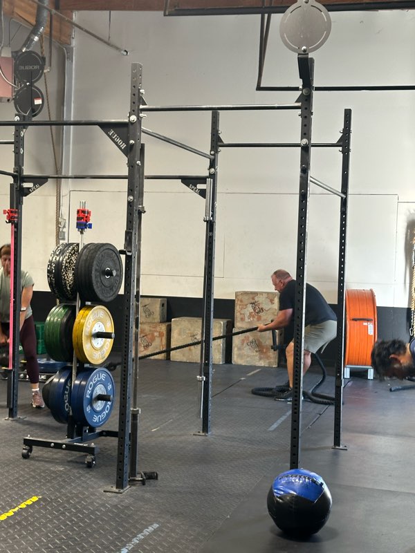 A member training at the rig next to the bumper plate rack.